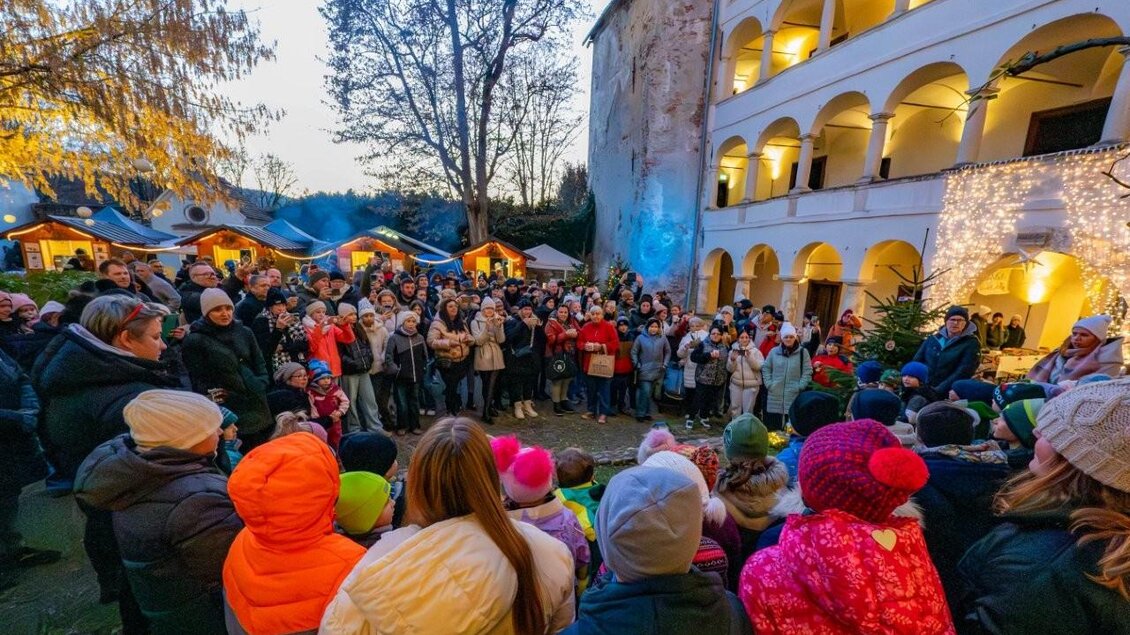 Eine große Menschenmenge versammelt sich auf einem Weihnachtsmarkt. Beleuchtete Stände und festliche Dekorationen schaffen eine gemütliche Stimmung. | © Günter Simmerl