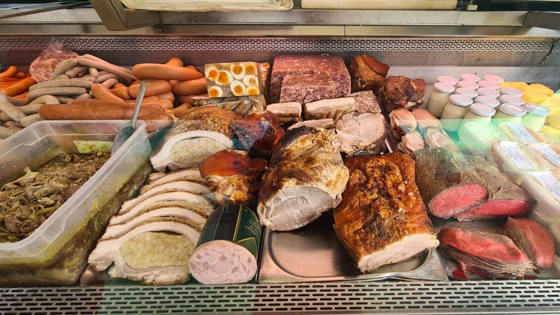 Eine Auswahl an verschiedenen Fleischsorten und Wurstwaren in einer Auslage. Dazu gehören köstliche Aufschnitt, Brötchen und frische Aufstriche. | © Winfried Büttner