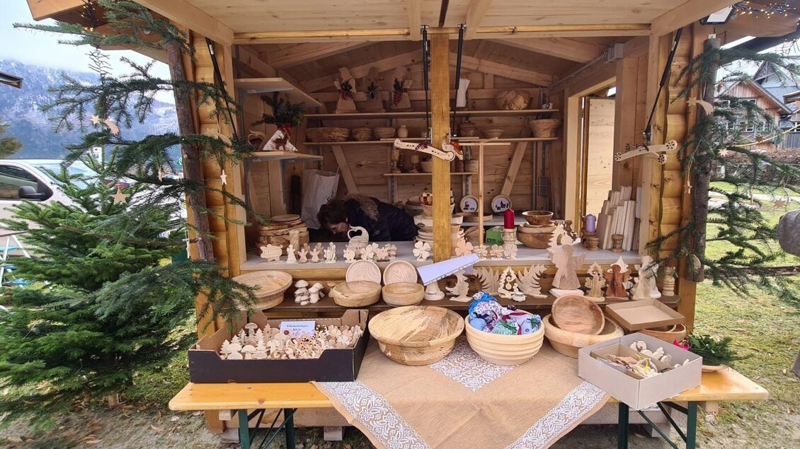 Ein kleiner Holzstand mit vielen handgefertigten Holzartikeln. Die Auslage umfasst Schalen, Figuren und Dekorationen in einer charmanten Umgebung. | © Winfried Büttner