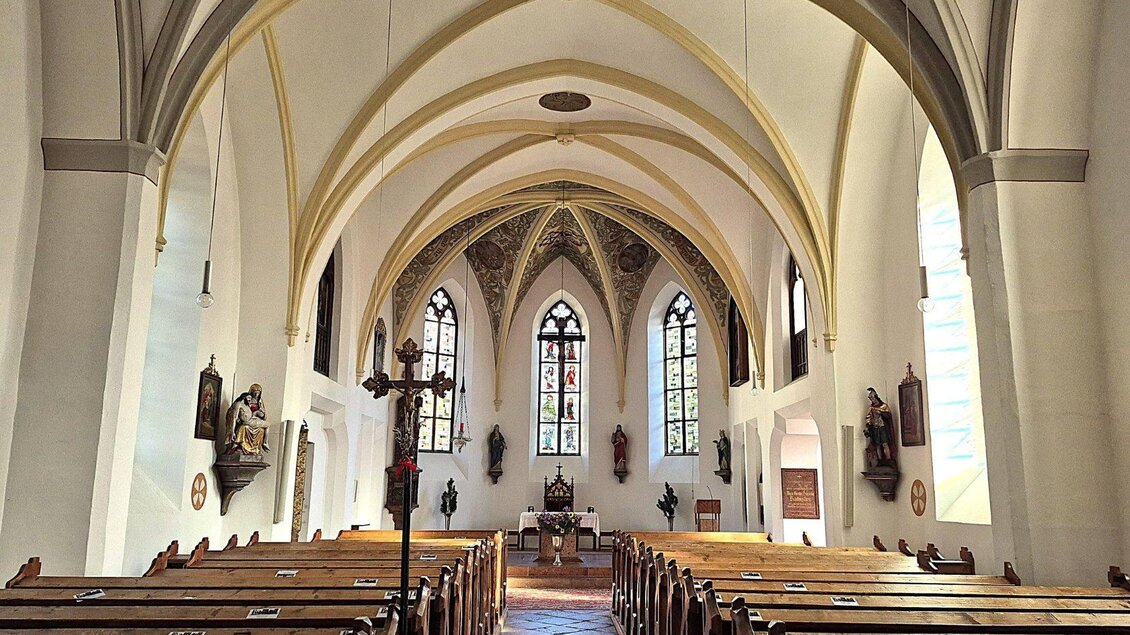 <p>Der Innenraum der Altausseer Pfarrkirche mit hohen Gewölben und bunten Fenstern. Bänke sind hintereinander aufgestellt und einige Figuren sind an den Wänden zu sehen.</p> | © Baumgartner Monika