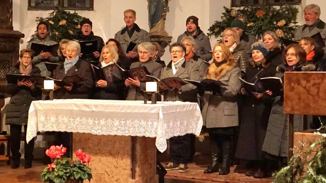 <p>Der Objektchor Altaussee beim Adventsingen in der Pfarrkirche Altaussee. Im Hintergrund sind festliche Dekorationen und ein Altar zu sehen.</p> | © Traudi Petritsch