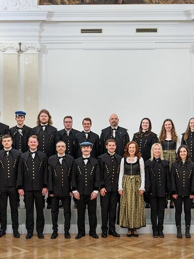Eine Gruppe von Menschen in traditioneller Kleidung steht in einem Raum mit heller Dekoration. Sie lächeln und posieren zusammen für das Foto. | © Harald Tauderer