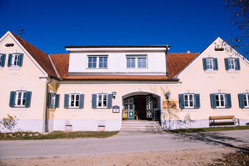 Ein schönes Gebäude mit einem roten Dach und grünen Fensterläden. Der Himmel ist blau und klar. | © Kurkommission Bad Blumau