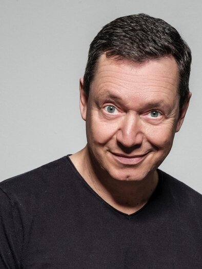 A man with short hair smiles at the camera. He is wearing a black T-shirt and has a friendly facial expression. | © c-stefan-gergely_2