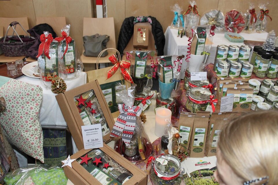 Ein farbenfrohes Weihnachtsmarkt-Setup mit vielen Geschenken und Produkten in dekorativen Verpackungen. Verschiedene Köstlichkeiten und dekorative Artikel sind auf einem Tisch ausgestellt. | © Gemeinde Gasen