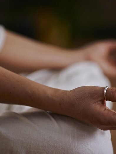 Eine Hand in Meditationshaltung. Der Hintergrund ist verschwommen und stammt aus einer ruhigen Umgebung. | © Pixabay