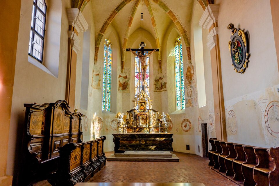 Ein schöner Innenraum einer Kirche mit einem Altar und farbigen Fenstern. Die Einrichtung ist schlicht und elegant, was eine ruhige Atmosphäre schafft. | © KHS- Fürstenfeld