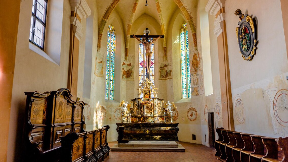 Ein schöner Innenraum einer Kirche mit einem Altar und farbigen Fenstern. Die Einrichtung ist schlicht und elegant, was eine ruhige Atmosphäre schafft. | © KHS- Fürstenfeld
