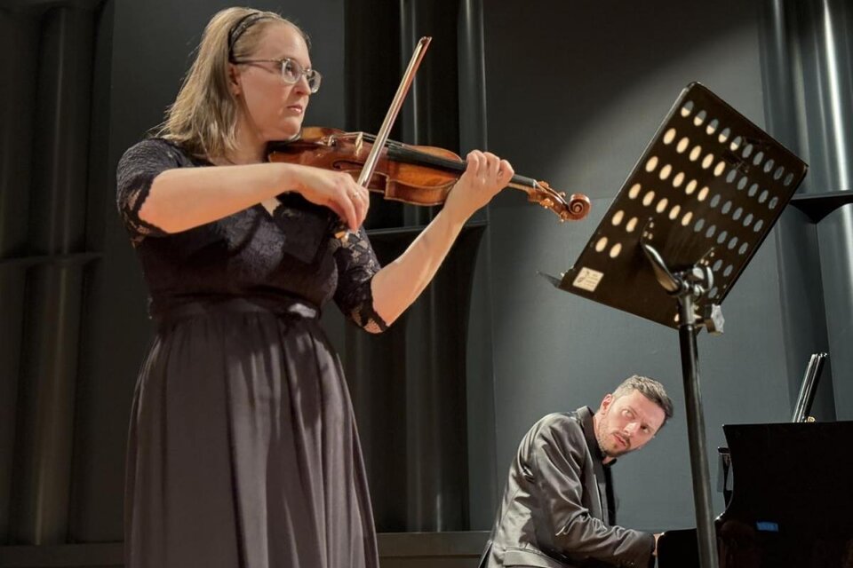 Im Vordergrund steht Hannelore Ramminger im schwarzen Kleid mit ihrer Geige. Sie wird von Philipp Scheucher am Klavier begleitet, der dahinter platziert ist. | © Oststeiermark Tourismus