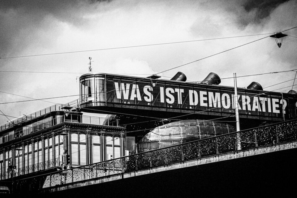 Historische Schwarz-Weiß-Aufnahme des Kunsthaus Graz mit dem Schriftzug „Was ist Demokratie?“ | © Bernd Grosseck