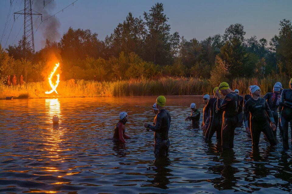 Triathleten im Neoprenanzug beim Schwimmstart eines eXtreme Triathlons in Gössendorf bei Morgendämmerung. | © Region Graz-Gerald Hirl