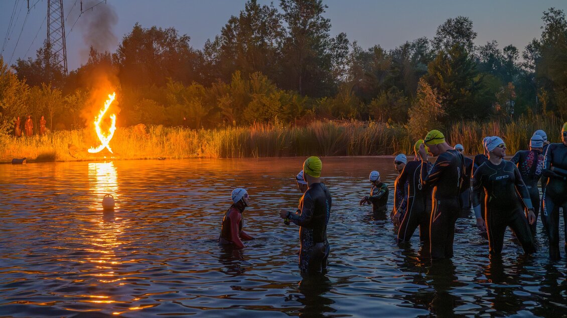 Triathleten im Neoprenanzug beim Schwimmstart eines eXtreme Triathlons in Gössendorf bei Morgendämmerung. | © Region Graz-Gerald Hirl