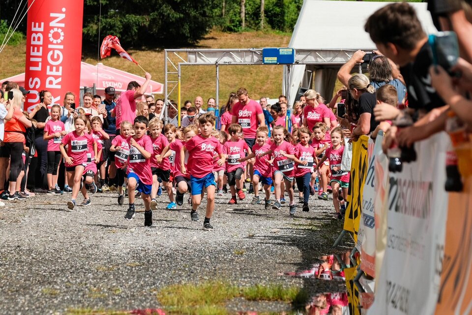 Viele Kinder in pinken T-Shirts rennen bei einem Wettlauf. Zuschauer an der Strecke feuern sie an. | © Stadtgemeinde Bärnbach