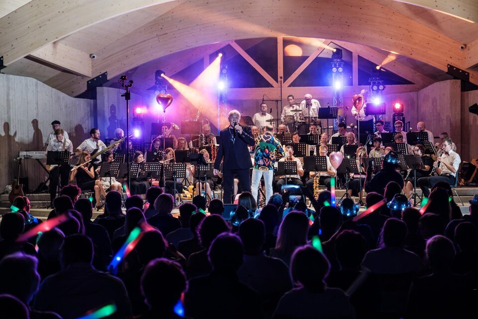 Konzert der Bergkapelle Oberdorf-Bärnbach im Stadtpark mit Orchester, Sänger und Publikum bei Abendstimmung. | © Bergkapelle Oberdorf-Bärnbach