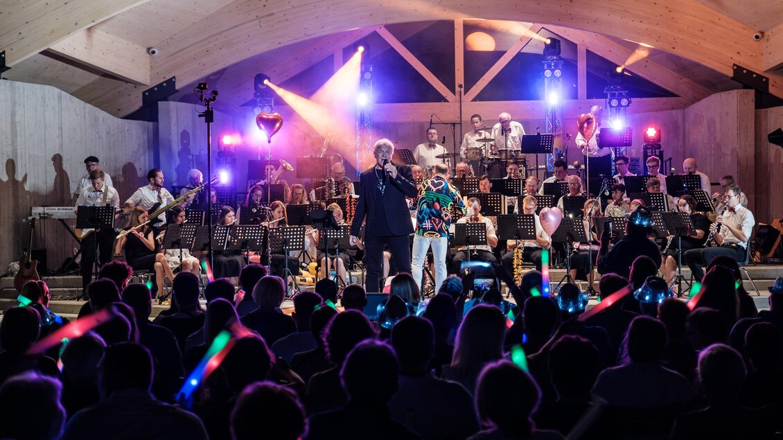 Konzert der Bergkapelle Oberdorf-Bärnbach im Stadtpark mit Orchester, Sänger und Publikum bei Abendstimmung. | © Bergkapelle Oberdorf-Bärnbach