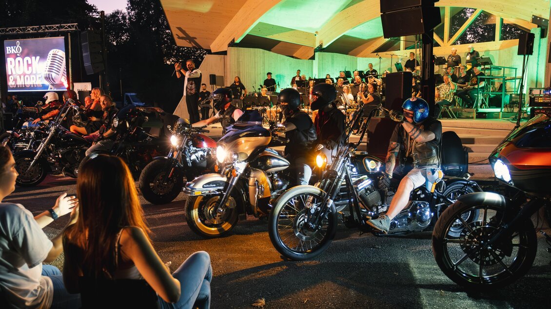Motorradfahrer vor der Bühne beim Open Air der Bergkapelle Oberdorf-Bärnbach im Stadtpark bei Abendstimmung. | © Bergkapelle Oberdorf-Bärnbach