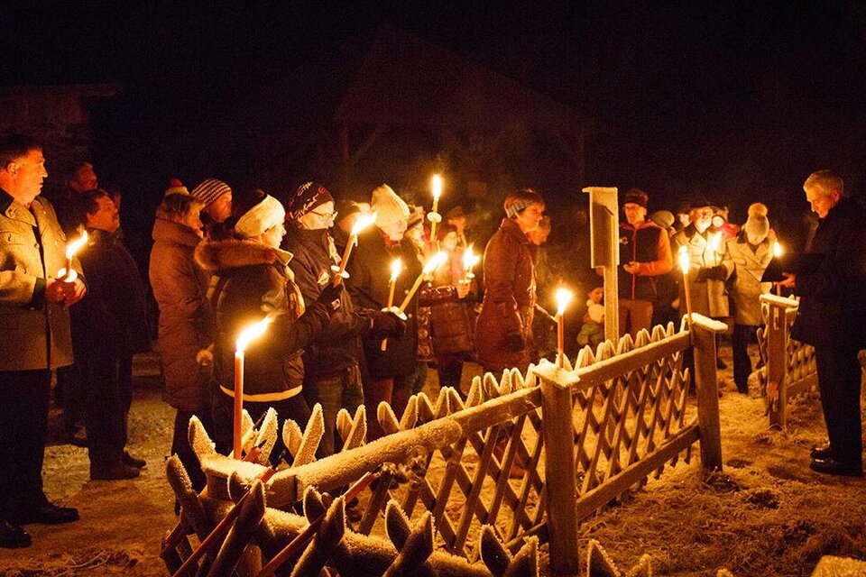 Eine Gruppe von Menschen versammelt sich nachts in einem frostigen Außenbereich. Sie halten Fackeln und stehen vor einem Holzzaun. | © Bergbauverein Öblarn