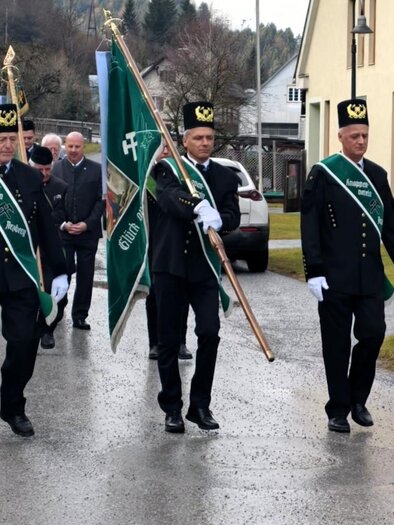 Egy egyenruhás férfiakból álló csoport vonul végig az utcán. Zászlókat és hagyományos ékszereket viselnek. | © Otto Schinnerl