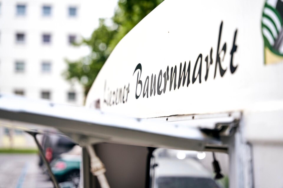 Ein Marktstand mit der Aufschrift "Kleiner Bauernmarkt". Der Stand steht in einem urbanen Umfeld. | © TV Liezen