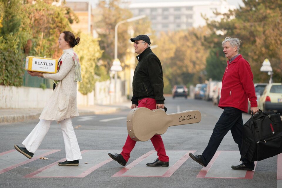 <p><p>Die drei Musiker*innen von Beatles im Packerl laufen über einen Zebrastreifen im Gleichschritt. Melissa Jank führt die Gruppe an, sie trägt ein Paket in den Händen auf welchem der Schriftzug Beatles zu lesen ist. Gefolgt von Michael Radanovics und Reinhard Köberl, welche je ein Musikinstrument tragen. Eine Homage an das berühmte Beatles-Cover. </p></p> | © Thomas Jank