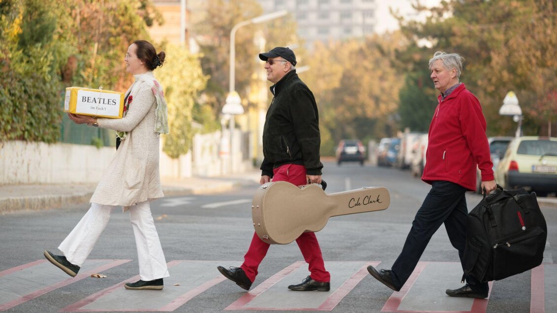 <p><p>Die drei Musiker*innen von Beatles im Packerl laufen über einen Zebrastreifen im Gleichschritt. Melissa Jank führt die Gruppe an, sie trägt ein Paket in den Händen auf welchem der Schriftzug Beatles zu lesen ist. Gefolgt von Michael Radanovics und Reinhard Köberl, welche je ein Musikinstrument tragen. Eine Homage an das berühmte Beatles-Cover. </p></p> | © Thomas Jank