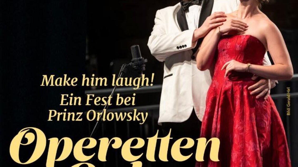 Ein Sänger im Anzug und eine Sängerin in einem roten Kleid stehen auf der Bühne. Sie präsentieren eine Operettengala mit einem festlichen Ambiente. | © Oststeiermark Tourismus