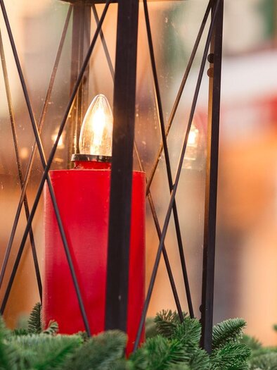 Black lantern with red LED candle and fir branches as decoration during mountain advent. | © Region Graz-Mias Photoart
