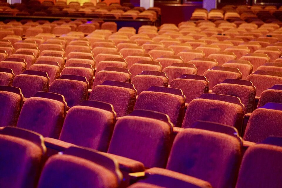 Ein geschmackvoller Theatersaal mit vielen roten Sitzen. Die Reihen sind ordentlich angeordnet und strahlen eine einladende Atmosphäre aus. | © Pixabay