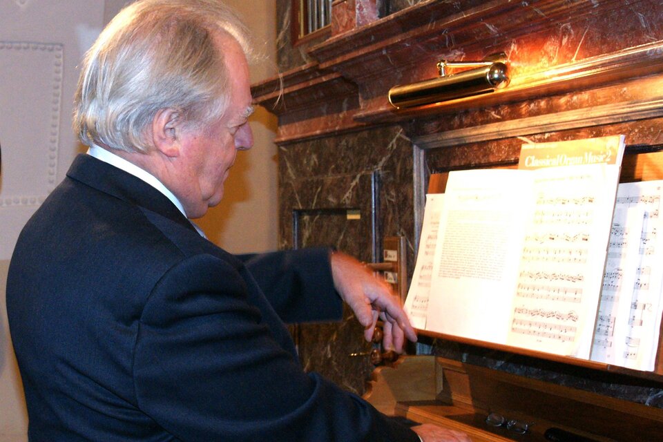 Ein Mann spielt an einer Orgel und schaut auf die Noten. Die Umgebung ist festlich und elegant. | © Sakralkunst Oststeiermark