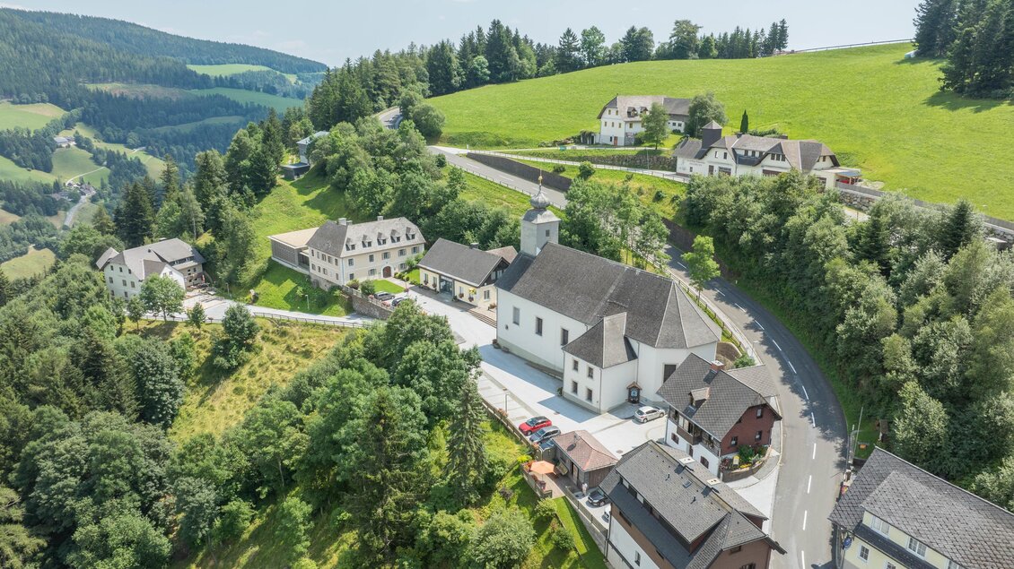 Ein malerisches Dorf inmitten von Hügeln und Wäldern. Die Häuser sind schön verteilt, umgeben von üppigem Grün und einer klaren Aussicht. | © Oststeiermark Tourismus