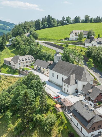 Ein malerisches Dorf inmitten von Hügeln und Wäldern. Die Häuser sind schön verteilt, umgeben von üppigem Grün und einer klaren Aussicht. | © Oststeiermark Tourismus