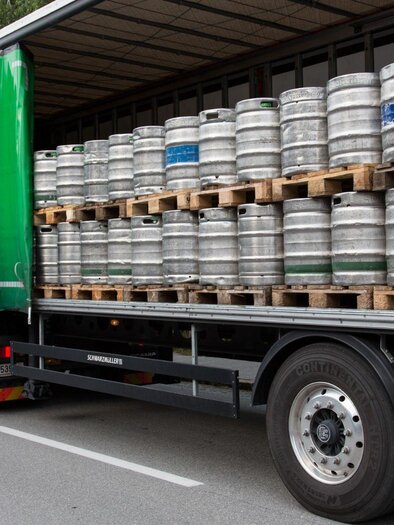 A truck with several stacked beer tap systems on the cargo area is parked on a street. Two people are standing next to the truck and are chatting. | © Feuerwehr Altaussee
