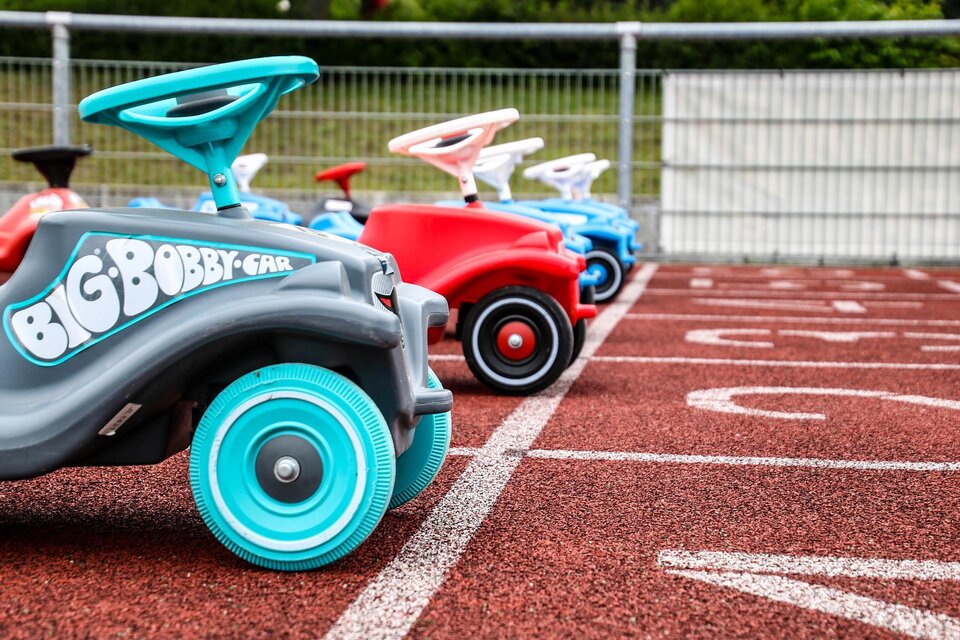 Eine Reihe von bunten Bobbycars steht auf einer Laufbahn. Die Fahrzeuge sind bereit für ein Rennen und zeigen verschiedene Farben. | © Pixabay