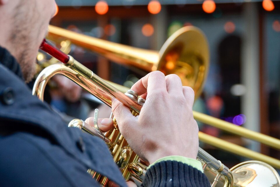 Ein Musiker spielt Trompete. Im Hintergrund sind verschwommene Menschen und Lichter zu sehen. | © pixabay.com