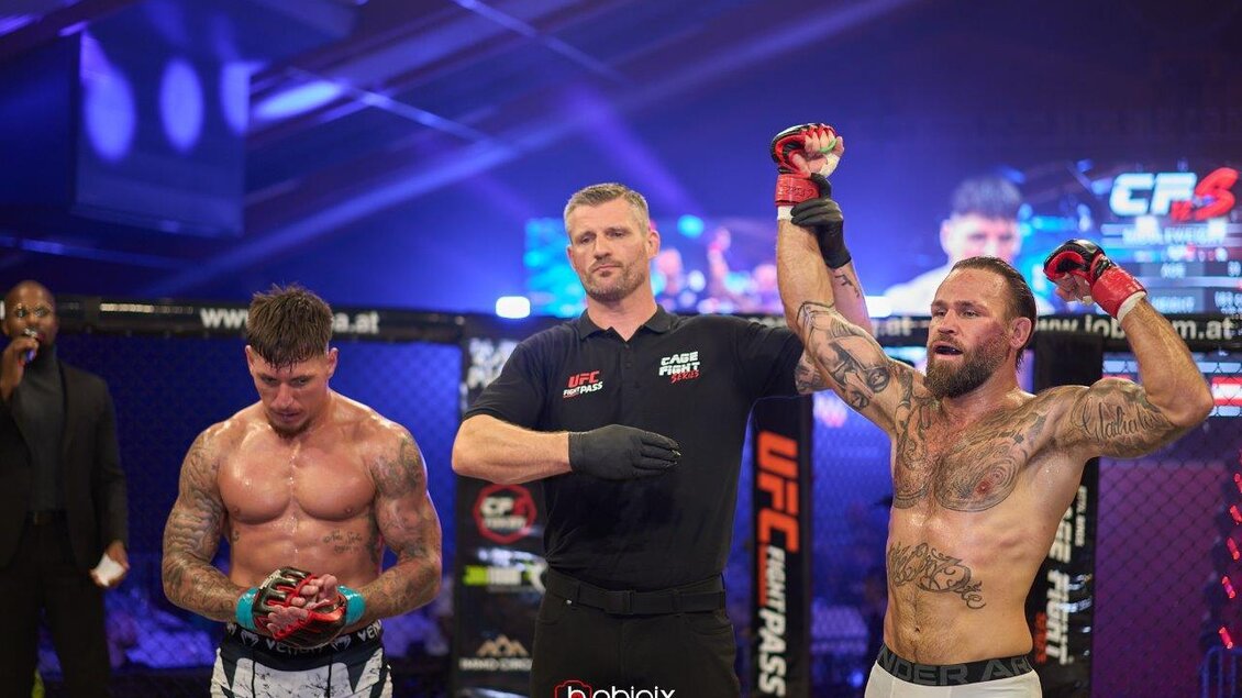 Ein Mixed-Martial-Arts-Kampf, bei dem ein Kämpfer den Sieg feiert. Im Hintergrund ist ein Ring und Zuschauer zu sehen. | © Bobipix