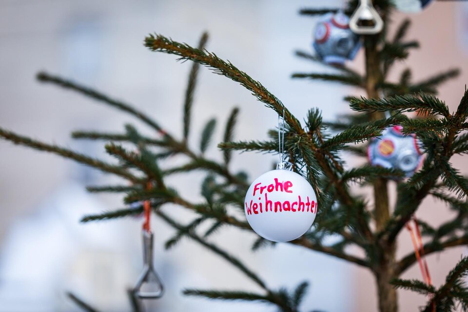 Ein geschmückter Weihnachtsbaum mit einer weißen Kugel, auf der "Frohe Weihnachten" steht. Im Hintergrund sind weitere Weihnachtsdekorationen zu sehen. | © TV MUrau