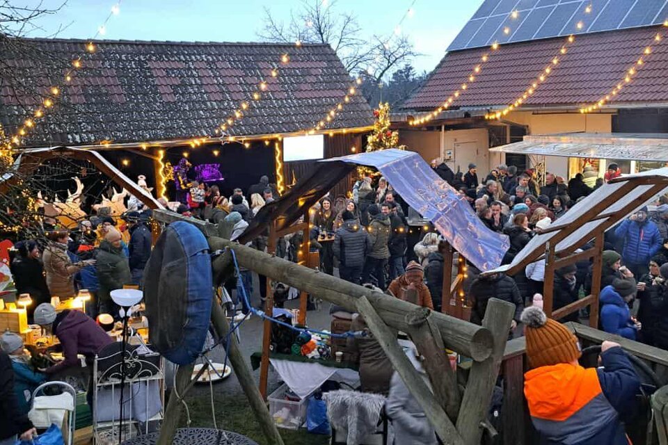 Besucher genießen den festlich beleuchteten Christkindlmarkt Da Finz in Mooskirchen mit Ständen und Lichtern. | © Da Finz