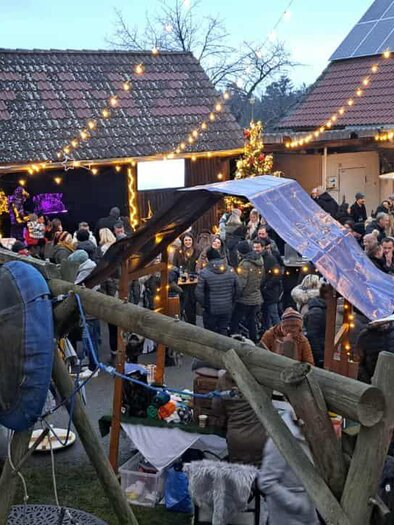 Visitors enjoy the festively illuminated Christkindlmarkt Da Finz in Mooskirchen with stalls and lights. | © Da Finz