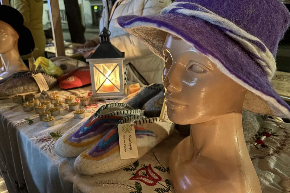 Ein Schaufenster mit einer klassischen Modepuppe, die einen lila Filzhut trägt. Im Hintergrund sind handgefertigte Schuhe und andere Waren auf einem Tisch ausgestellt. | © Oststeiermark Tourismus