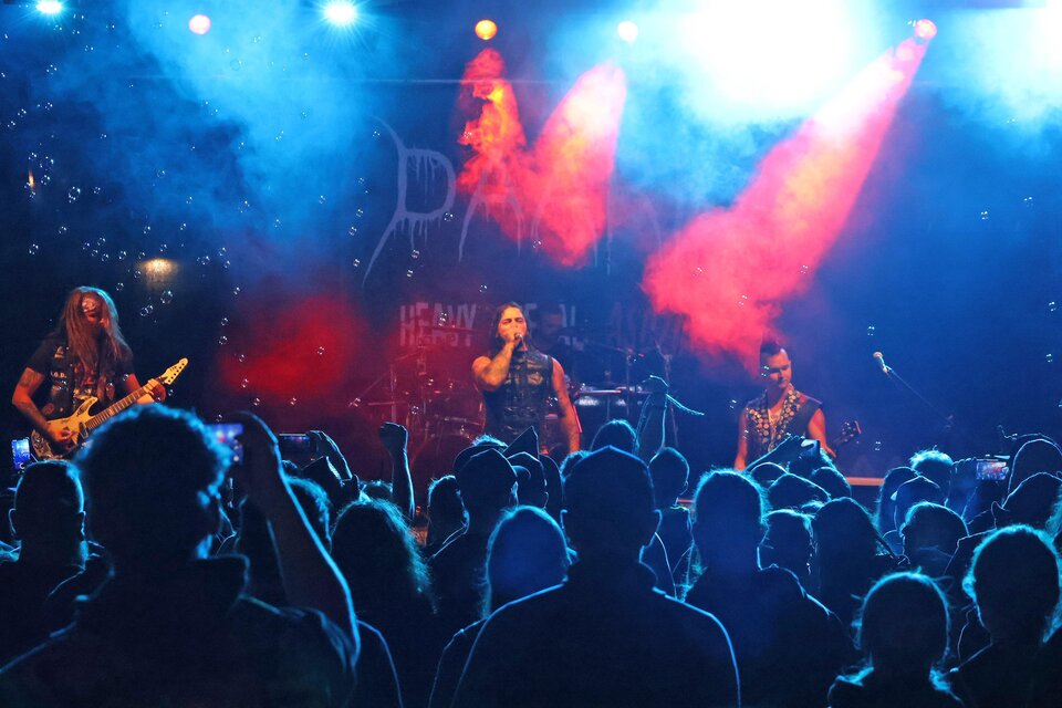 Eine Live-Band spielt vor einem begeisterten Publikum. Die Bühne ist mit buntem Licht und Nebel beleuchtet. | © Stadt Bruck