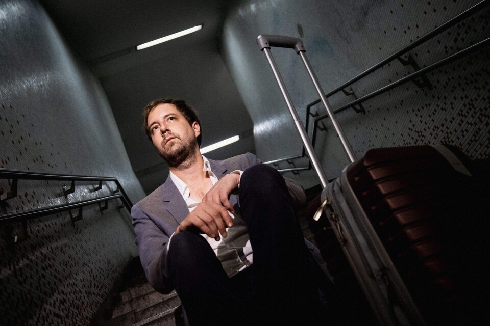 Ein Mann sitzt mit einem Koffer auf der Treppe eines U-Bahnhofes. Er schaut nachdenklich in die Ferne. | © Christopher Glanzl