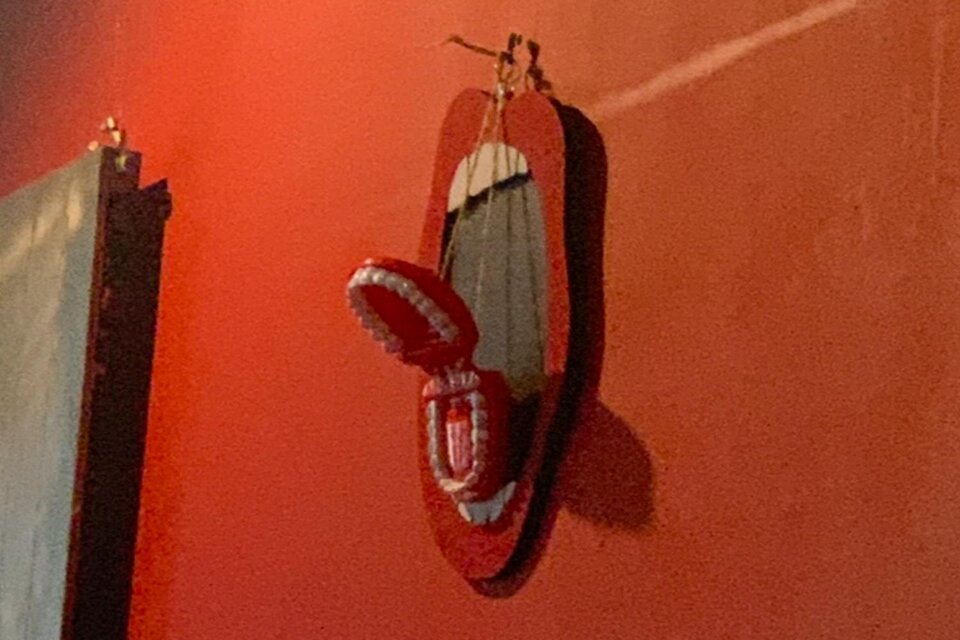 Ein rotes Wandbild mit einem Skateboard und einem Paar rote Flip-Flops. Der Hintergrund ist ebenfalls rot und sorgt für einen auffälligen Kontrast. | © Lena Pöltl.