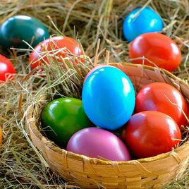 Colorful Easter eggs are lying in a small basket on hay. The eggs come in different colors and are festively decorated. | © Pixabay