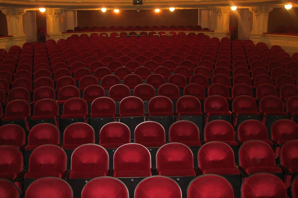 Ein Theater mit vielen leeren roten Sitzen. Die Wände sind hell und die Beleuchtung sorgt für eine angenehme Atmosphäre. | © Pixabay