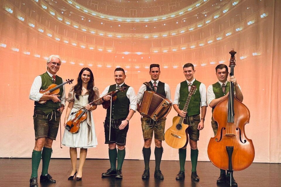 <p><p>Die Ausseer Bradlmusi mit 6 Musikanten und Musikantinnen, gekleidet in Tracht. Sie halten ihre Instrumente in der Hand und stehen fröhlich nebeneinander auf einer Bühne. </p> | © Ausseer Bradlmusi