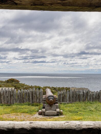 Ein Aussichtspunkt mit einer Kanone, die auf das Meer zeigt. Im Hintergrund sind Wolken und eine natürliche Landschaft zu sehen. | © Irmgard Unger-Eisele-Scroll durch dein Leben!