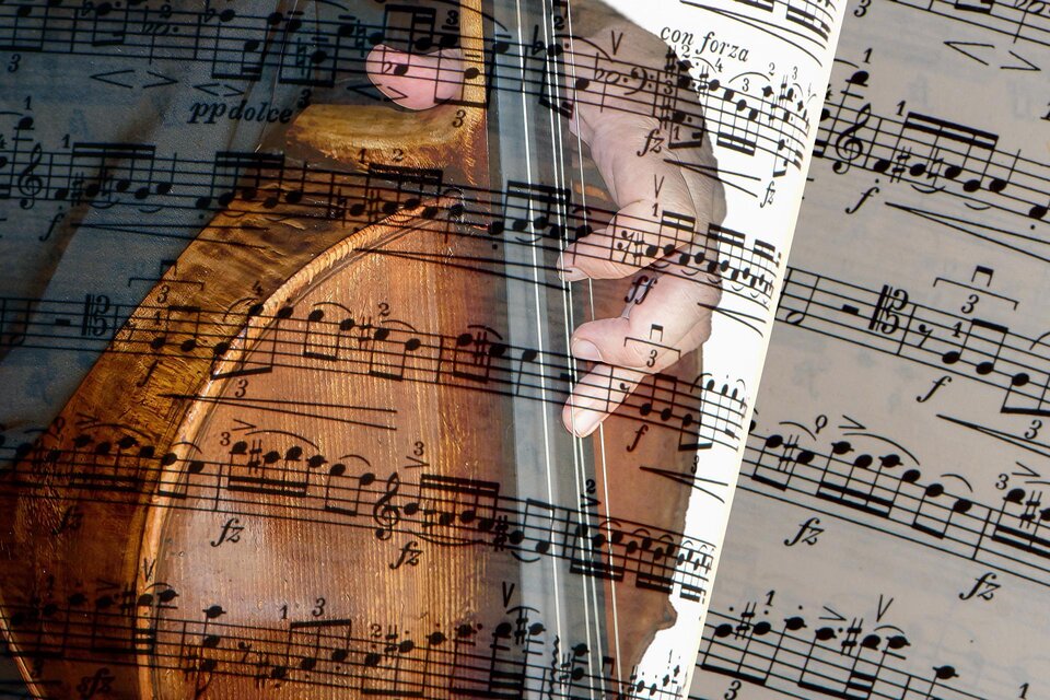 Eine Hand spielt ein Instrument, während Musikalnoten im Hintergrund sichtbar sind. Die Kombination aus Instrument und Noten vermittelt einen musikalischen Eindruck. | © Pixabay