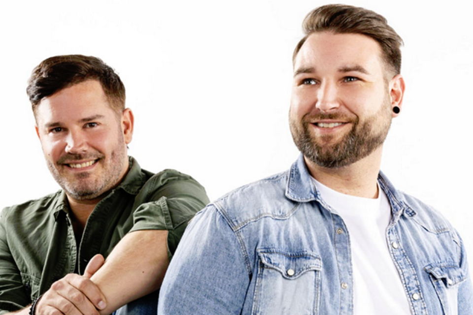 Die zwei Männer der Austro-Pop Band EDMUND stehen nebeneinander und lächeln. Sie tragen lässige Kleidung und haben einen freundlichen Ausdruck. | © Bruno Bounty Photography