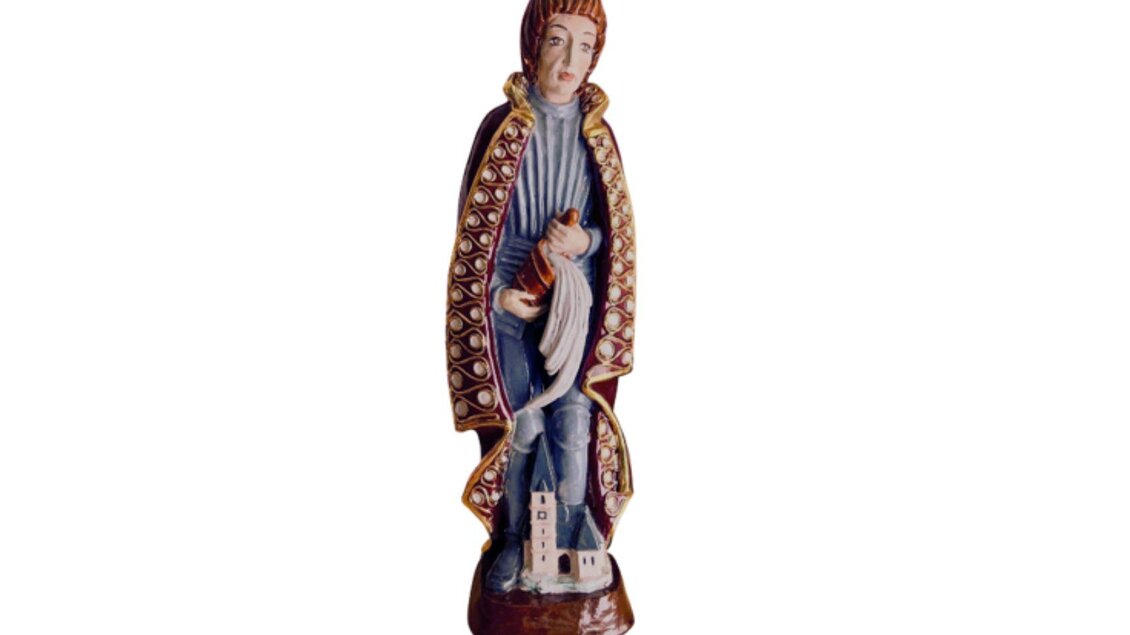 Die bemalte keramische Figur zeigt eine stehenden Person in historischer Kleidung. Zu ihren Füßen befindet sich ein kleines Kirchenmodell. | © Kammerhofmuseum Bad Aussee, kammerhofmuseum.at