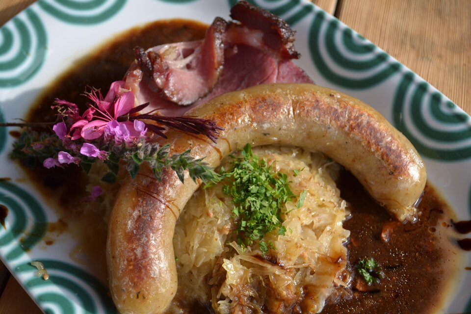 Erdapfelwurst mit Beilagen im Almwirtshaus Holdahütt'n auf der Sommeralm